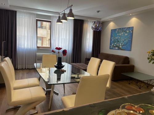 a dining room and living room with a table and chairs at Luxury Apartments In Top City Center Varna 1 in Varna City