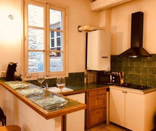uma cozinha com um balcão com dois copos de vinho em Le MOKA Charmant Appartement au coeur de ville em Nîmes