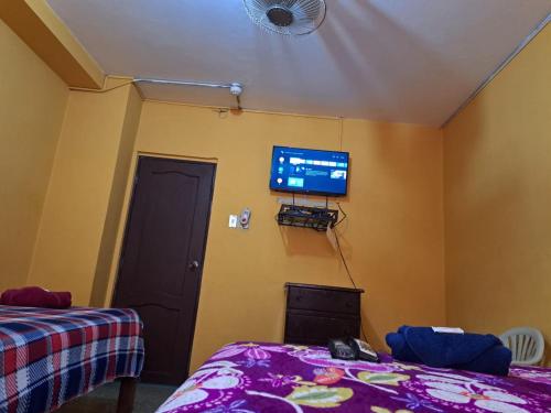1 dormitorio con 1 cama y TV en la pared en Hotel Berlín, en Guayaquil