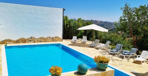 - une piscine avec des chaises et un parasol dans l'établissement La Vigna di Ranco Agriturismo, à Paglieta