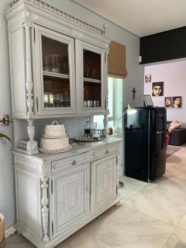a kitchen with a large white cabinet and a black refrigerator at Beach & Mountain Retreat within a UNESCO Biosphere in Rooiels