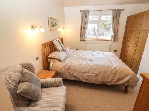 a bedroom with a bed and a couch at Lilac Cottage in Windermere