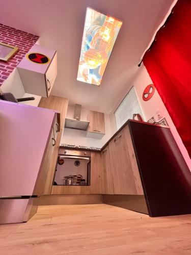 une petite cuisine avec des placards en bois et une cuisinière dans l'établissement Le Marvel - AVENGERS, à Bédarieux