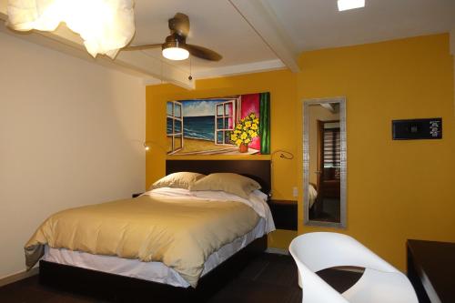 a yellow bedroom with a bed and a ceiling fan at Terra Vista in Guanajuato