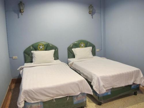 two beds in a hospital room with white sheets at The Star Hotel in Udon Thani