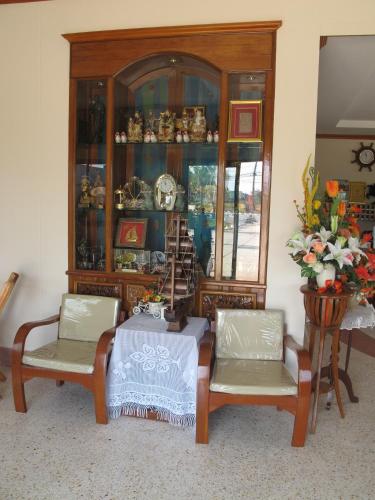 a china cabinet with two chairs and a table at The Star Hotel in Udon Thani