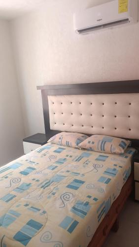 a bedroom with a bed with a white and blue comforter at Renta departamento por día en Acapulco in Acapulco