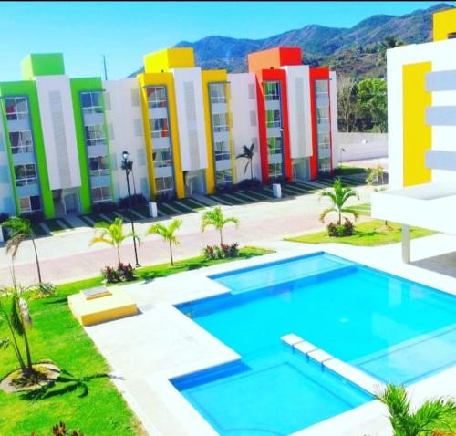 a building with a pool in front of it at Renta departamento por día en Acapulco in Acapulco