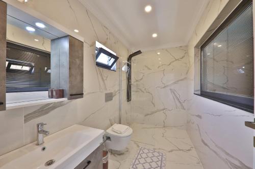 baño con lavabo y aseo y ventana en Exclusive Villas Kalkan, en Çayköy