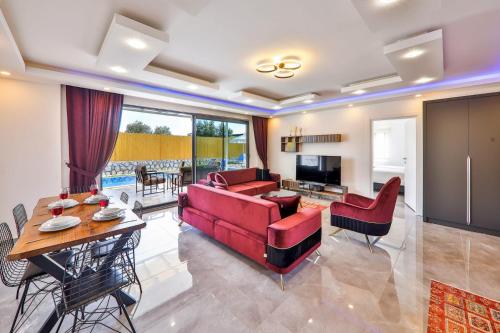 Çayköy的住宿－Exclusive Villas Kalkan，客厅配有红色的沙发和桌子