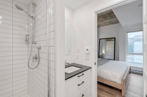 a white bathroom with a shower and a sink at INITIAL / Parisianer / Centre-ville de Québec in Quebec City