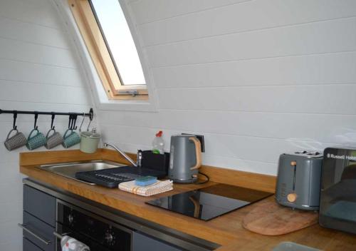 uma cozinha com um balcão com um lavatório e um fogão em Goat Hill Lodge em Broome