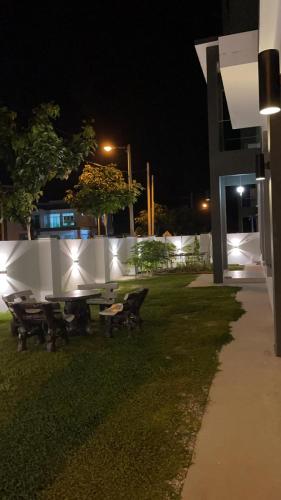 a table and benches in a yard at night at 福氣安康 Ray’s Homestay in Batu Pahat