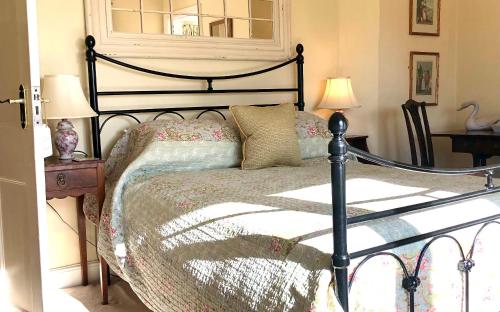 um quarto com uma cama, 2 candeeiros e uma janela em Farthings Country House Hotel & Restaurant Tunton em Taunton