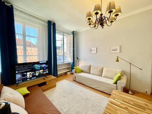 uma sala de estar com um sofá e uma televisão em ROYAL 2 Old Town fast WiFi Netflix HBO AppleTV+ em Varsóvia