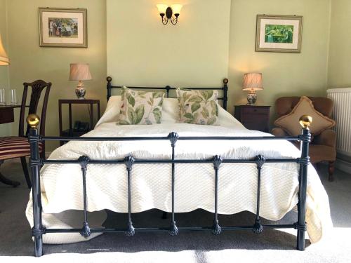 um quarto com uma cama e 2 cadeiras e 2 candeeiros em Farthings Country House Hotel & Restaurant Tunton em Taunton