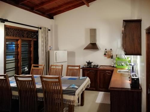 a kitchen with a table and chairs in a kitchen at Villa One64 Beach Front - Apartments in Hikkaduwa