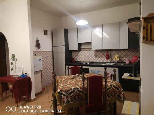 a kitchen with white cabinets and a table with a table cloth at APE REGINA Rignano Gramsci in Rignano Flaminio