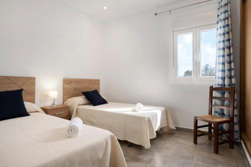 a bedroom with two beds and a window at Villa Montemedio - Paco in El Soto