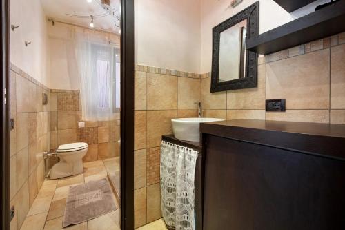 uma casa de banho com um WC, um lavatório e um espelho. em Appartamento Amedeo em Bardolino