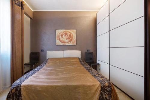 1 dormitorio con 1 cama y una pintura en la pared en Appartamento Amedeo, en Bardolino