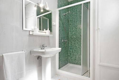 a white bathroom with a sink and a shower at Villa Montenmedio 1 in El Soto