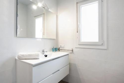 a white bathroom with a sink and a mirror at Villa Montenmedio - Juande in El Soto