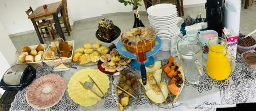 einen Tisch mit vielen verschiedenen Lebensmitteln in der Unterkunft Do Parque Pousada Comfort in Penha