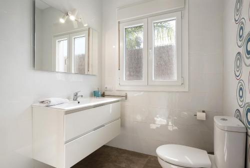 un bagno bianco con un water e un lavandino di Villa Montenmedio - Carmelo a El Soto