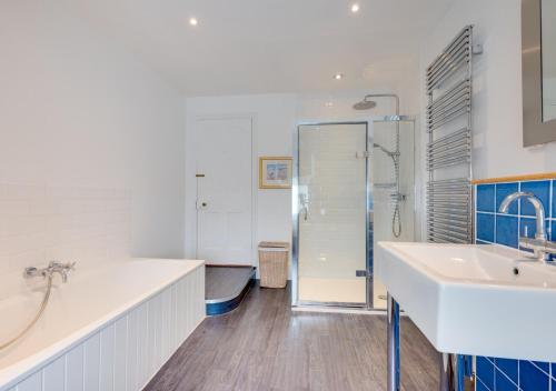 uma casa de banho com 2 lavatórios e um chuveiro em Forest Lodge em Southwold