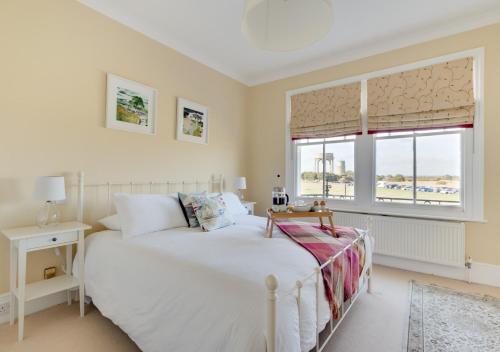 um quarto com uma cama branca e uma janela em Forest Lodge em Southwold