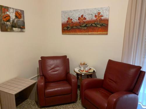 a room with two chairs and a table and a painting at Erythrà Bed and Breakfast in Reggio Calabria
