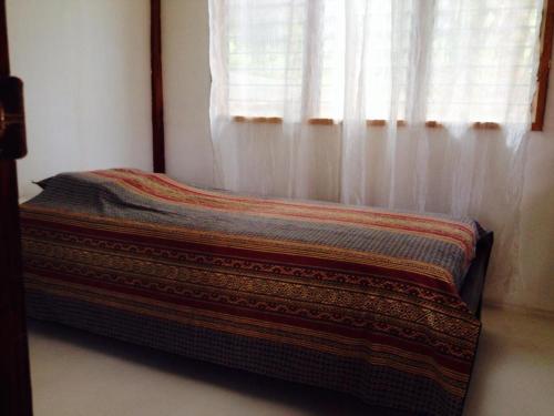a bed sitting in a room with a window at Liwayway sa Bohol Pamilacan Resort in Baclayon