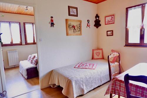 een kleine slaapkamer met een bed en een spiegel bij Petit chalet de montagne avec espace extérieur in Labaroche
