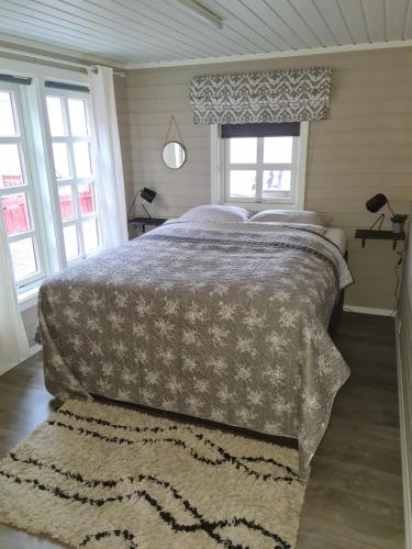 Schlafzimmer mit einem Bett, einem Fenster und einem Teppich in der Unterkunft Feriehus ved Saltstraumen in Bodø