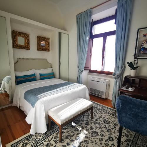 a bedroom with a large bed and a window at Chalet Vitorino in Sintra