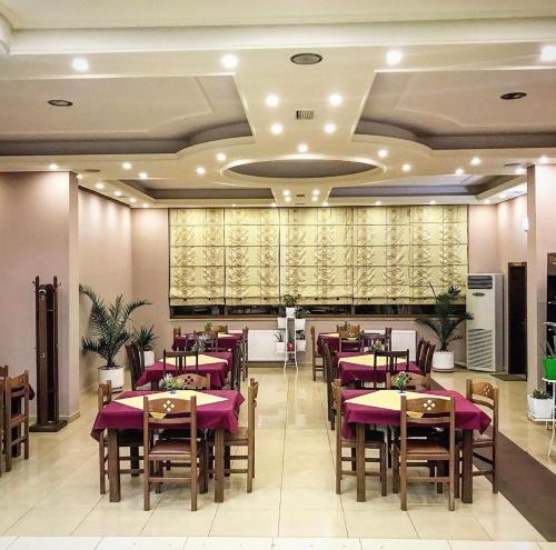 um restaurante com mesas e cadeiras com toalha de mesa roxa em Hotel Paradise em Bilisht
