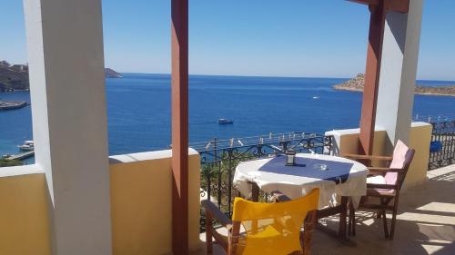 a table and chairs on a balcony with a view of the ocean at Melina's Sunset in Myrties
