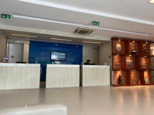 a lobby with a bar in the middle of a building at Flat - Navegantes Residence Hotel in Recife
