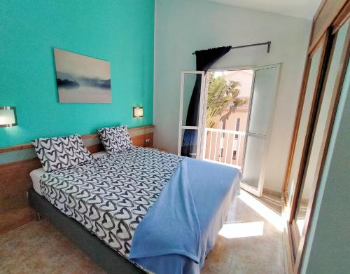 ein Schlafzimmer mit einem Bett und einem großen Fenster in der Unterkunft Green Oasis Maspalomas garden 11 in Maspalomas