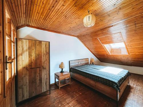 ein Schlafzimmer mit einem Bett und einer Holzdecke in der Unterkunft PANOS PALACE in Pramanta