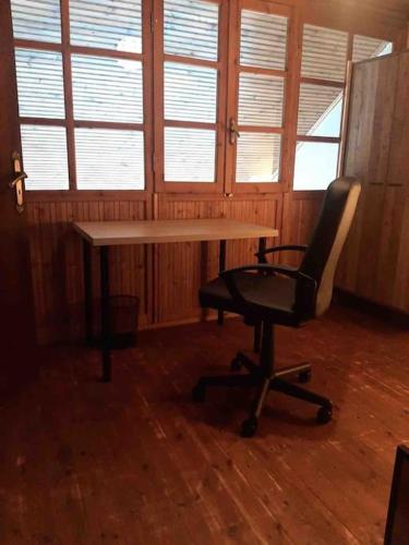 a desk and a chair in a room with windows at PANOS PALACE in Pramanta