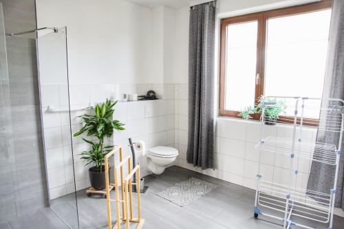 a bathroom with a toilet and plants in it at Haff Ostseeferienhaus unteres Apartment in Mönkebude