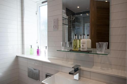 een badkamer met een wastafel en een spiegel bij Lochiel Villa Guest House in Fort William