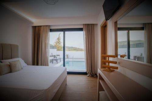 a hotel room with a bed and a large window at Villa Etoile in Ayios Kirikos
