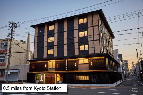 un grand bâtiment avec des fenêtres donnant sur une rue de la ville dans l'établissement MONday Apart Premium KYOTO Station, à Kyoto