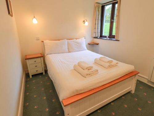 a bedroom with a bed with two towels on it at Park Cottage in Ambleside