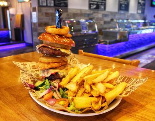 a plate of food with a hamburger and french fries at Palm Grove 2- Golden Palm - Pet friendly, WiFi, bed linen, central heating - Meadow Lakes Caravan & Lodge Hire in Chapel Saint Leonards