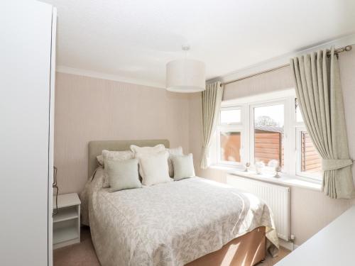 a white bedroom with a bed and a window at 12 Bucklesham Park in Ipswich