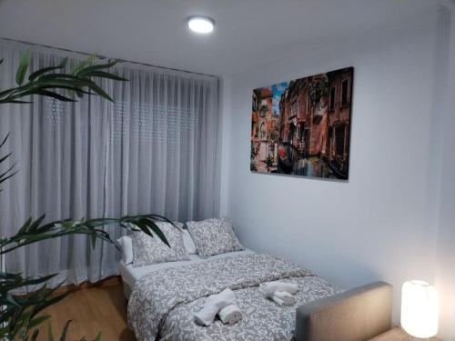 Un dormitorio con una cama y una planta en maceta. en Apartamento amplio, luminoso y confortable CC, en Madrid